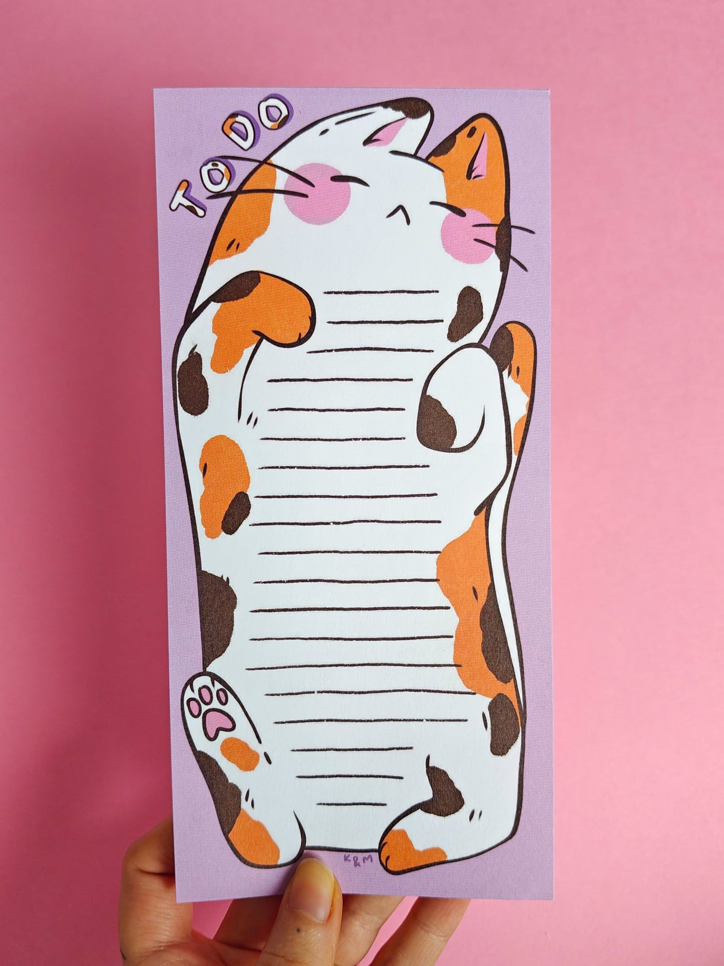 Notepad with a cat illustration on a pink background