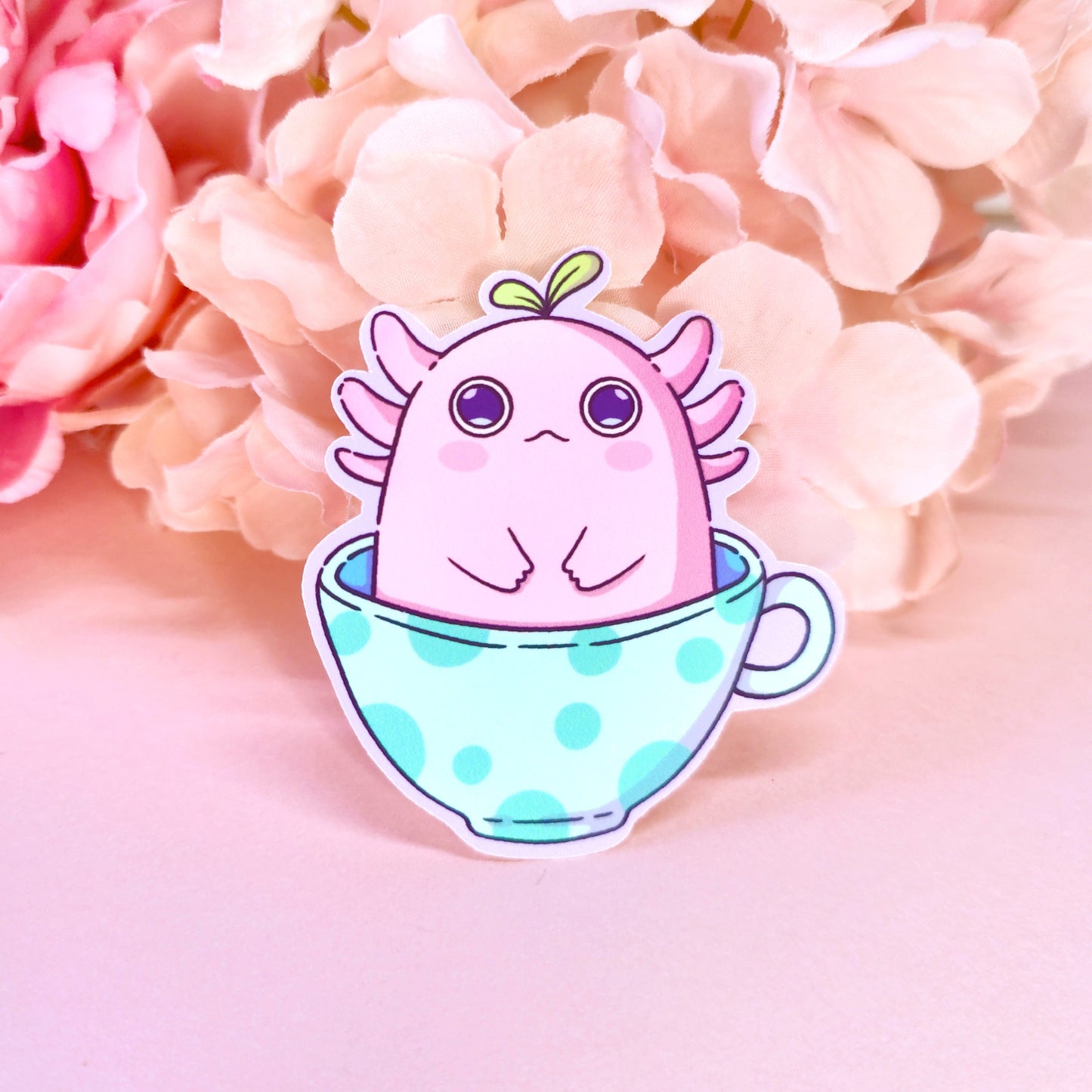Matte vinyl die-cut sticker featuring alotl things – a kawaii axolotl with wide eyes sitting in a teacup, printed in Ireland, 5x7cm