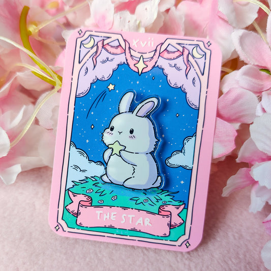 Cartoon rabbit holding a star on a card with pink border, surrounded by flowers.