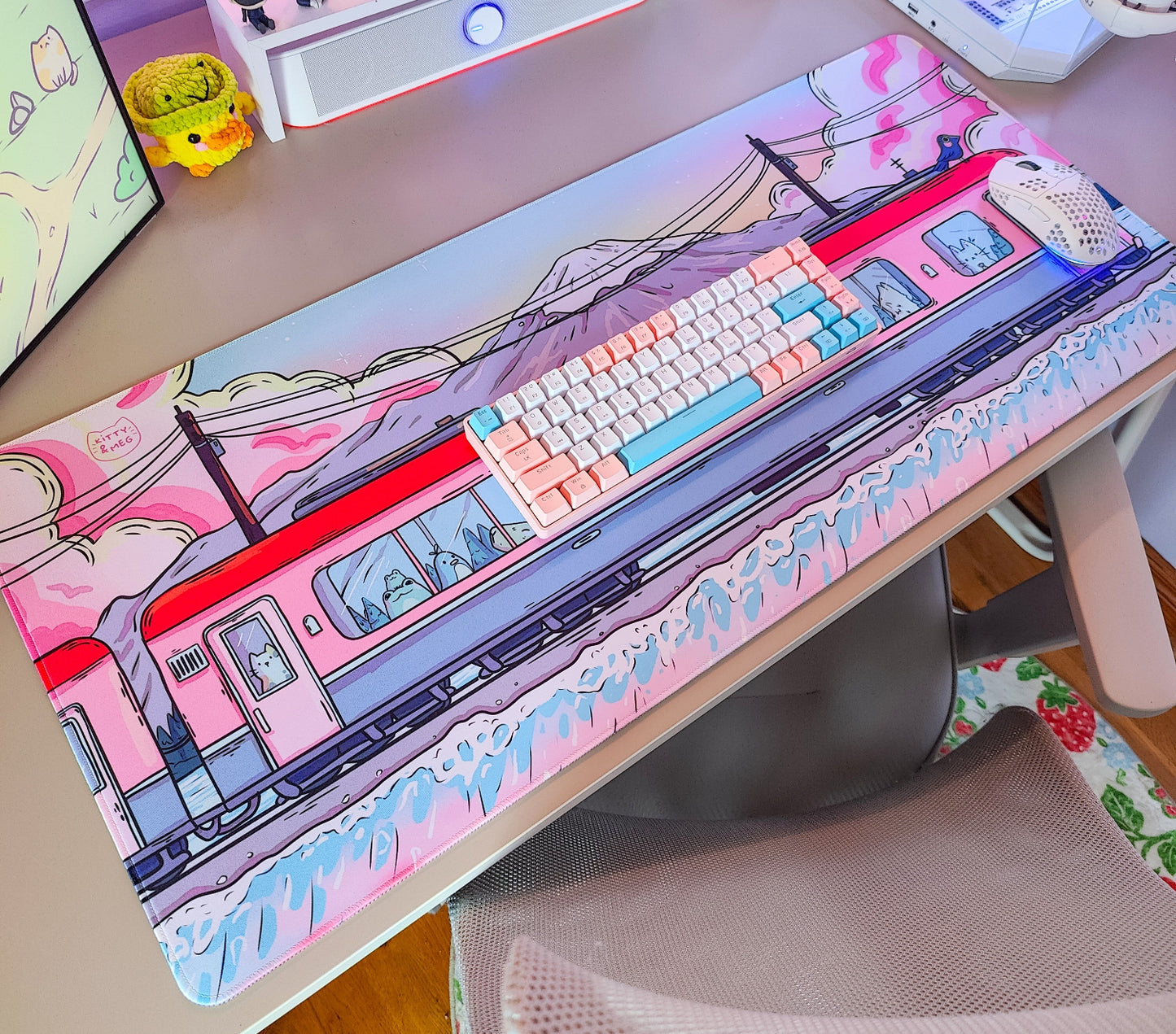 Desk setup with a large mouse pad featuring a train design.