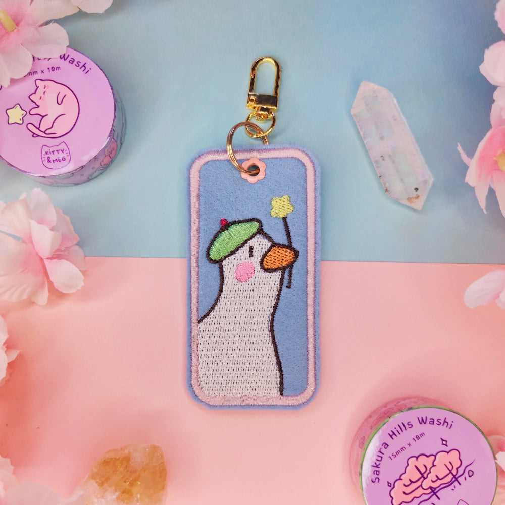 Keychain with cartoon character on a colorful background with flowers and washi tape.