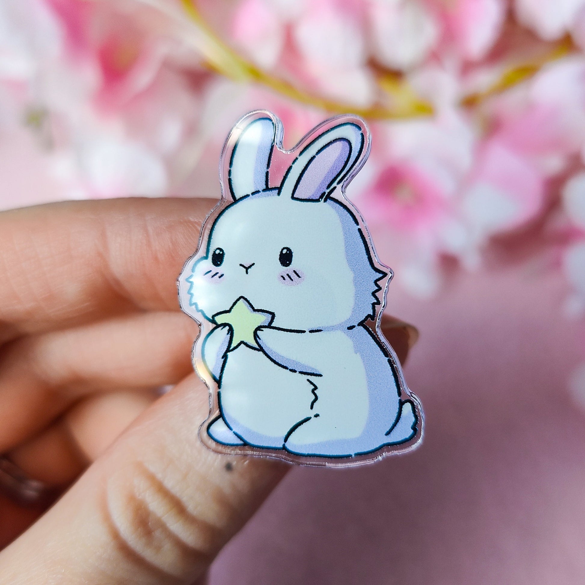 Cartoon bunny holding a star on a finger with a blurred pink floral background