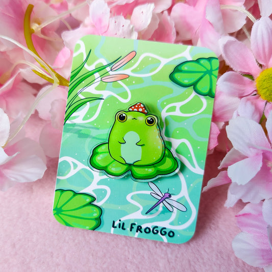 Lil Froggo acrylic pin – cute frog on lilypad with mushroom hat on backing card