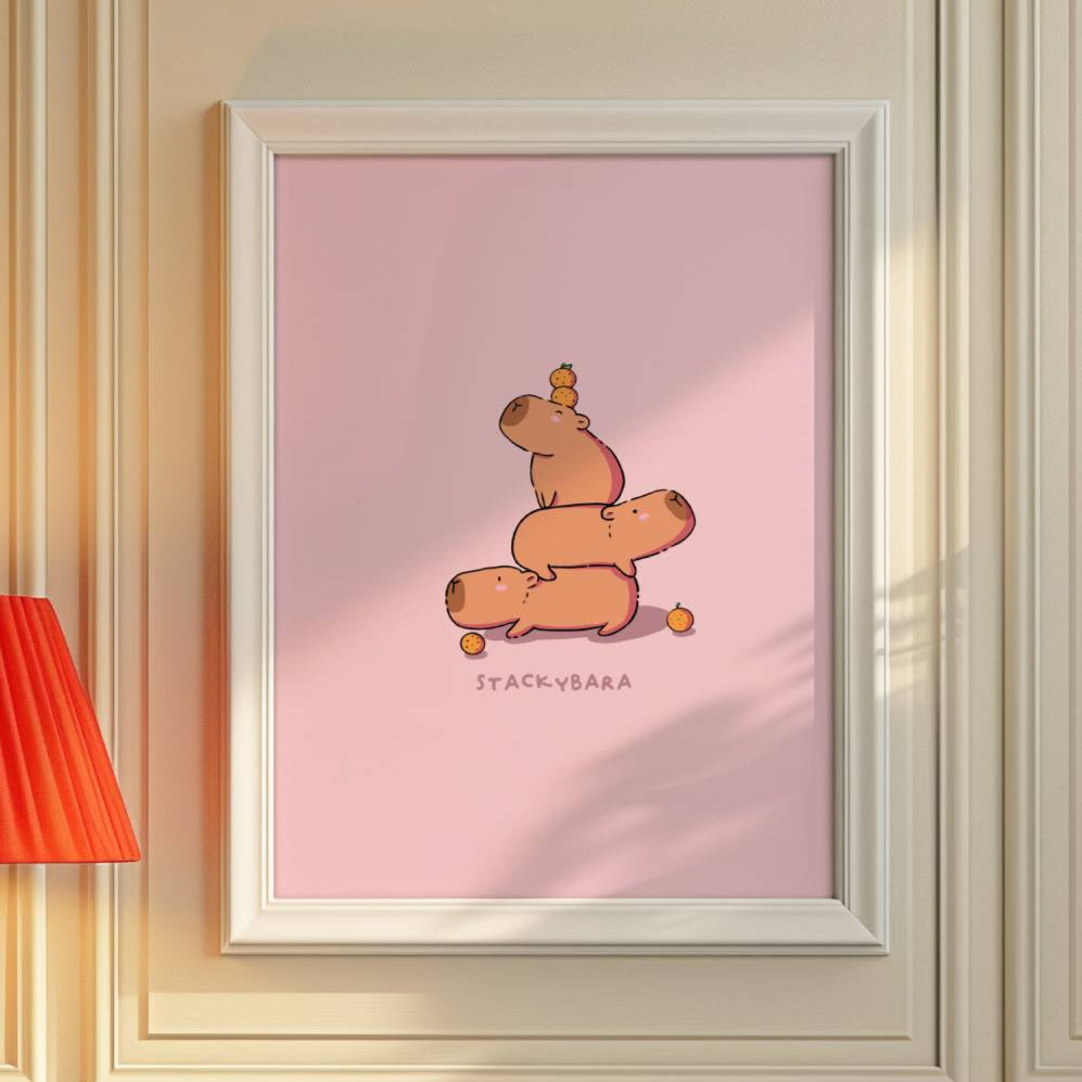 Framed artwork on a wall with a red lamp and pink chair in a room. cute caybara illustration